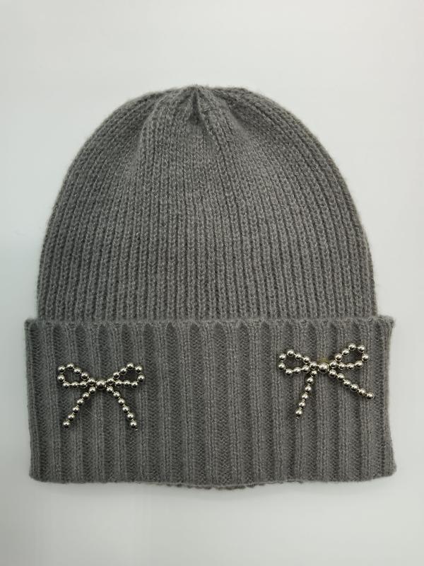 Grey ribbed knit winter beanie hat with two silver beaded bow brooches on folded cuff, flat lay on white background - contact for custom design quote