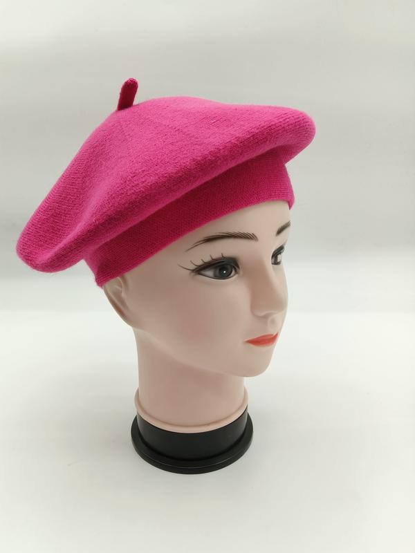 Hot pink wool knit French beret hat displayed on a mannequin head, side view showing classic round shape and center top button - corporate gift customization