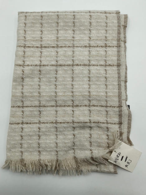 Folded ivory and beige woven plaid throw blanket with fringe trim and textured grid pattern - boutique retail bulk order