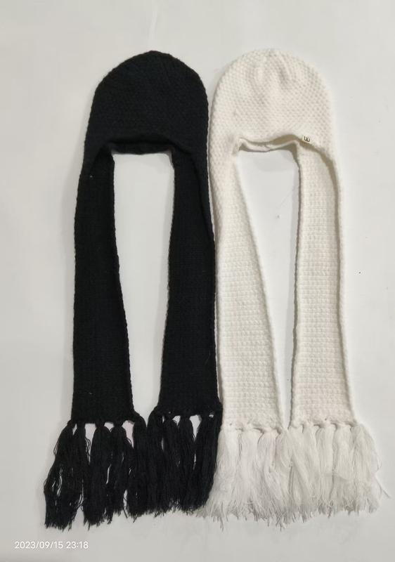 Two knitted hooded scarf hats with long tasseled ends laid flat, one black and one white, earflap balaclava winter style - request quote reply same day