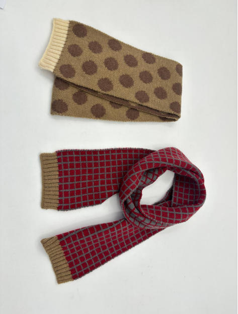 Two knit scarves flat lay: tan with brown polka dots and cream ribbed ends, red with gray grid pattern and khaki ribbed ends - no MOQ for stock designs