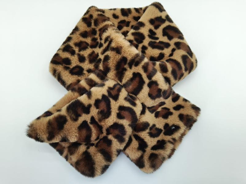 Leopard print faux fur scarf wrap laid flat on white background, showing brown and tan animal print pattern - gift shop wholesale supplier