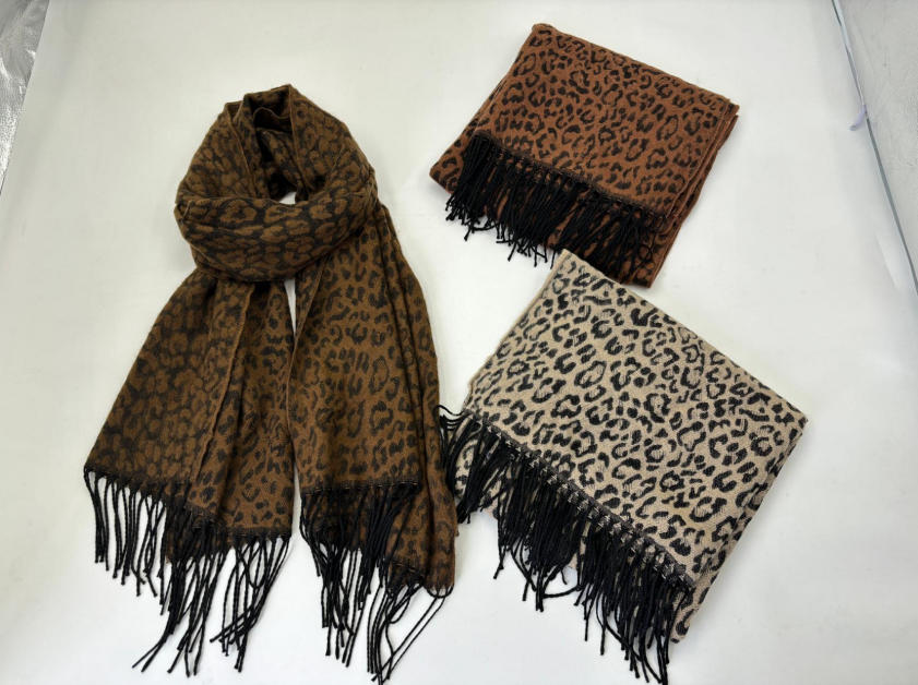 Three leopard print scarves with black fringe in dark brown, caramel brown, and beige colorways laid flat on white surface - bulk order 500+ pcs extra 8% off