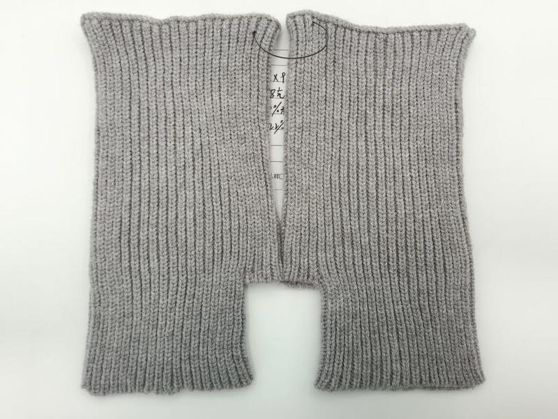 Pair of light gray ribbed knit fingerless gloves laid flat on white background, showing fine rib texture and open finger design - Oeko-Tex Standard 100 certified