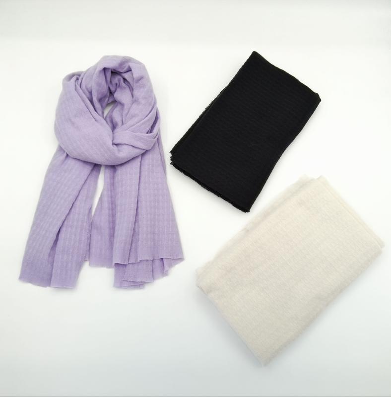 Three lightweight ribbed scarves displayed on white background: one draped in lavender, one folded in black, one folded in cream - EU REACH compliant material