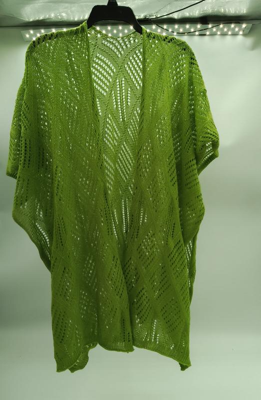 Lime green crochet lace kimono cardigan with diamond chevron pattern hanging on black hanger against white wall - BSCI audit passed supplier
