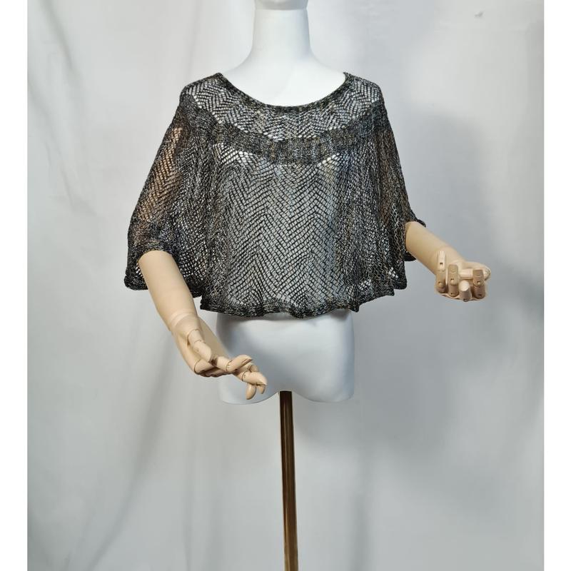 Cropped open-knit metallic silver and black cape poncho displayed on white mannequin with wooden articulated arms - ask bulk pricing get discount