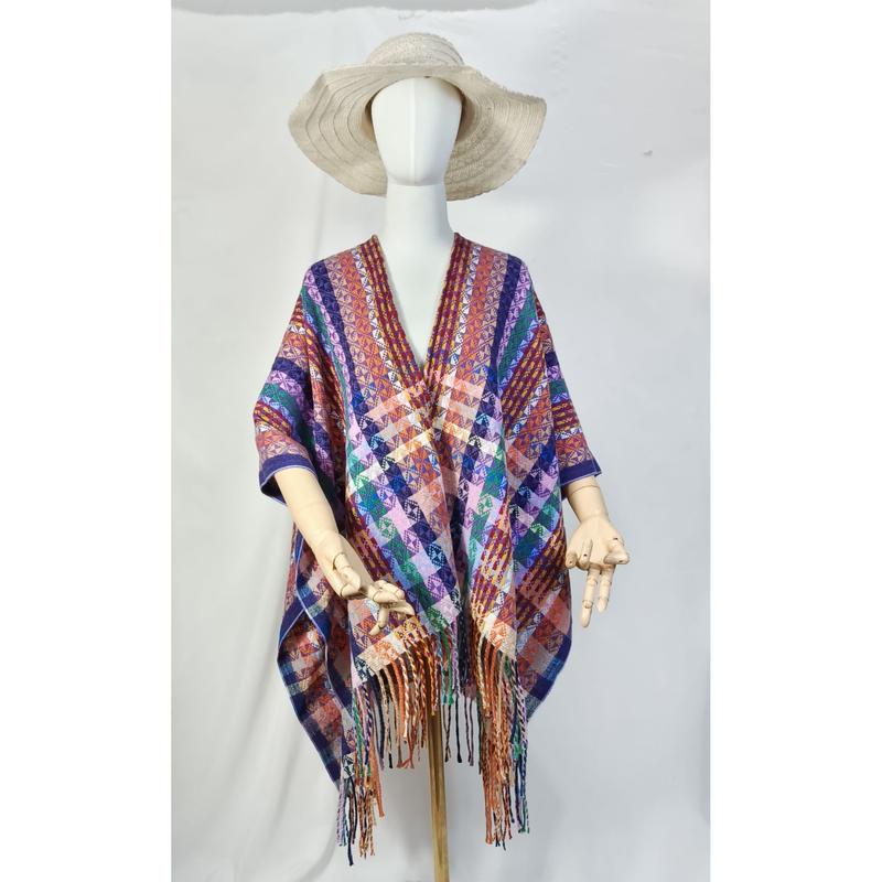Mannequin wearing multicolor geometric woven poncho with fringe hem and wide-brim straw hat on white background - no MOQ for stock designs