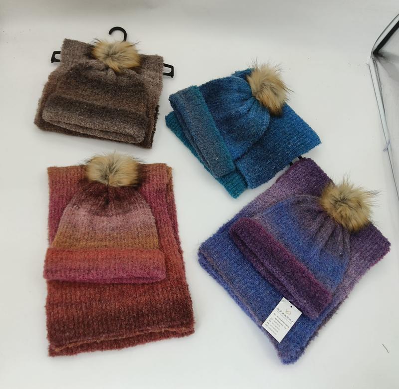 Four knit hat and scarf sets in brown, blue, red-orange gradient, and purple gradient, each with a faux fur pompom - corporate gift customization