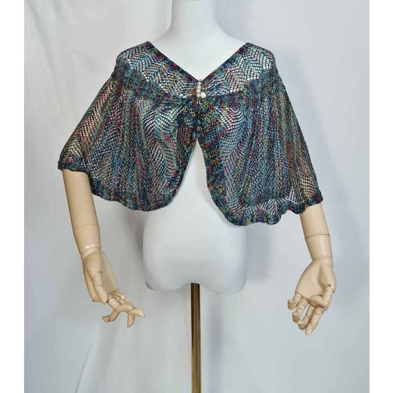 Multicolor open-weave knit capelet in teal, red, and gold displayed on a mannequin with wooden articulated arms - hotel amenity scarf supplier