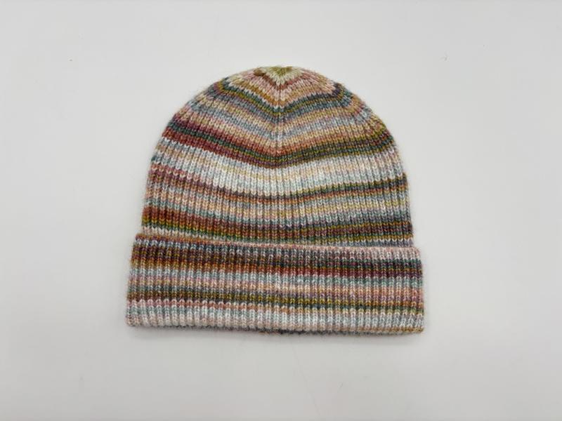 Knitted beanie hat with multicolor space-dyed stripes in pink, green, blue and brown tones, folded cuff, on white background - corporate gift customization
