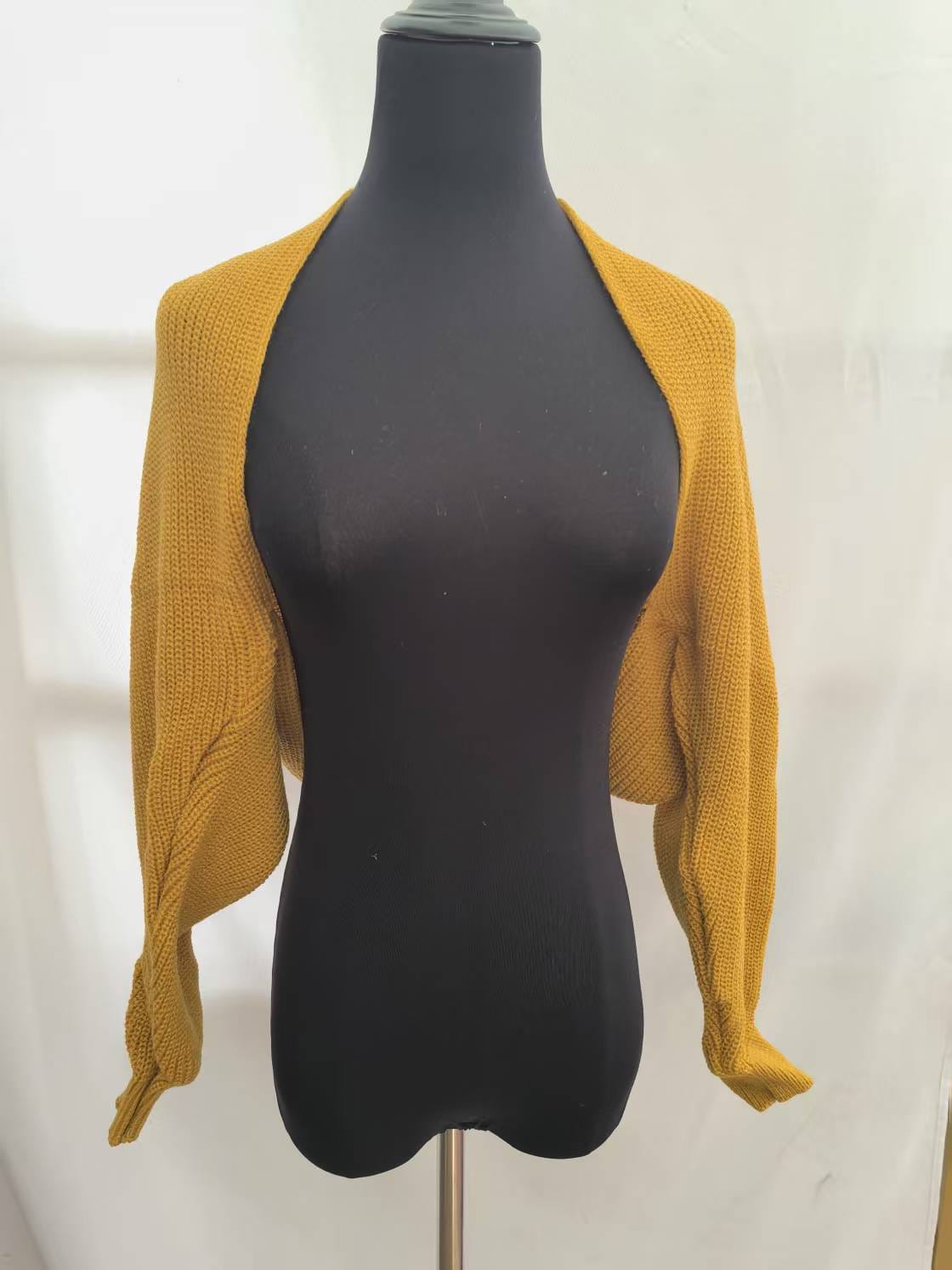 Mustard yellow chunky knit cropped bolero shrug with long sleeves displayed on a black dress form mannequin - winter accessories wholesaler