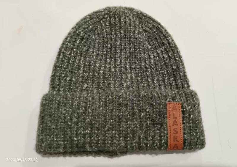 Olive green chunky ribbed knit beanie hat with folded cuff and brown leather Alaska patch label on white background - 5-day digital sample ready