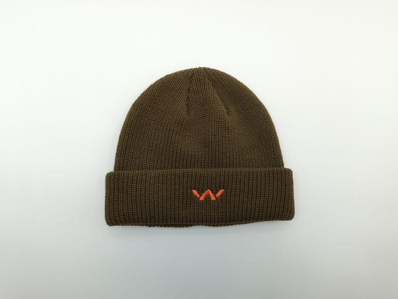 Olive green ribbed knit beanie hat with folded cuff and small orange embroidered logo, photographed flat on white background - BSCI + Oeko-Tex + GRS certified