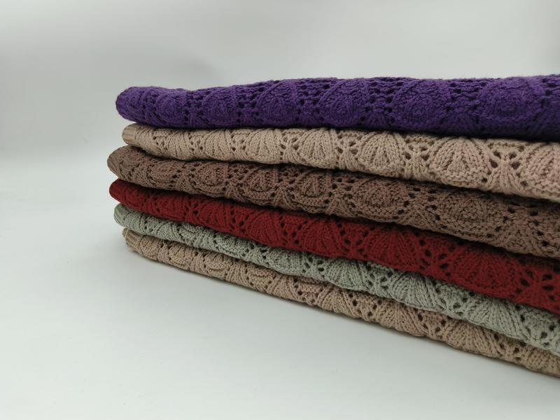 Stack of six folded lace knit throw blankets in purple, beige, taupe, red, sage green, and tan with floral openwork pattern - custom size no extra charge