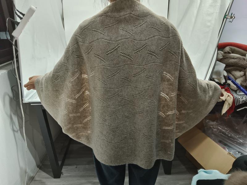 Back view of a woman wearing an oversized beige pointelle knit cardigan with batwing sleeves and wave lace pattern - express production 15 days