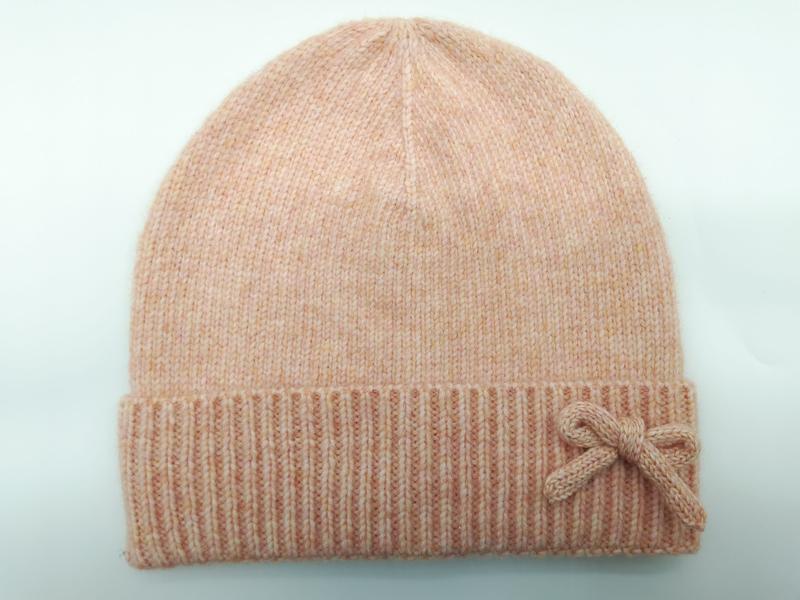 Soft peach marl knit beanie hat with folded ribbed cuff and decorative knitted bow accent on light background - sample order 10pcs available