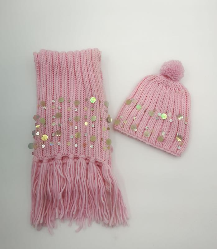 Pink ribbed knit winter scarf with fringe and sequins paired with matching pom-pom beanie hat on white background - sample order 10pcs available