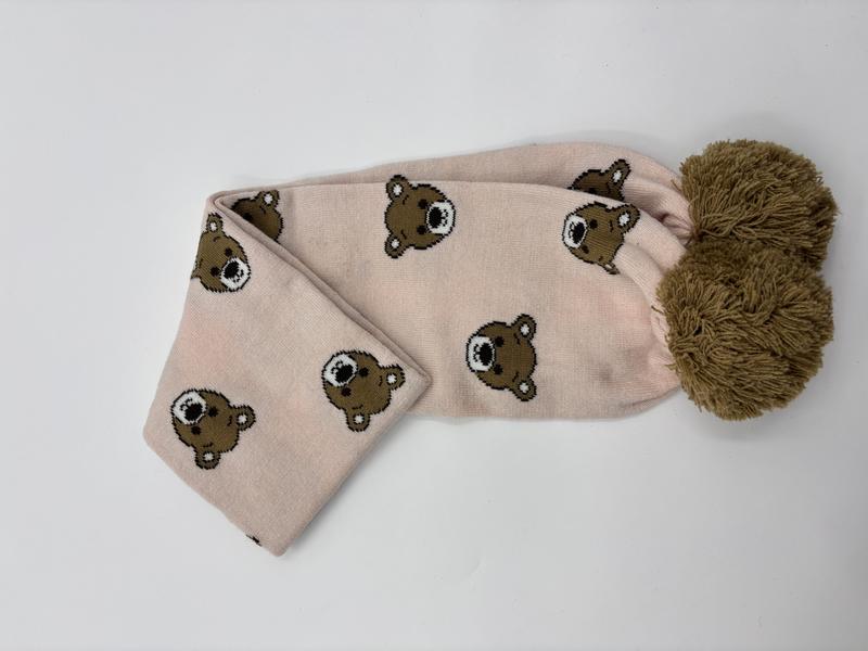 Pink knitted scarf with all-over teddy bear face pattern and large olive green pom-pom end detail - wholesale price for Europe buyers
