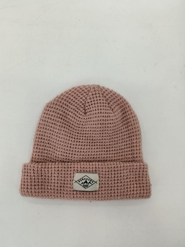 Dusty pink waffle knit cuffed beanie hat with woven label patch on white background - wholesale price for Middle East buyers