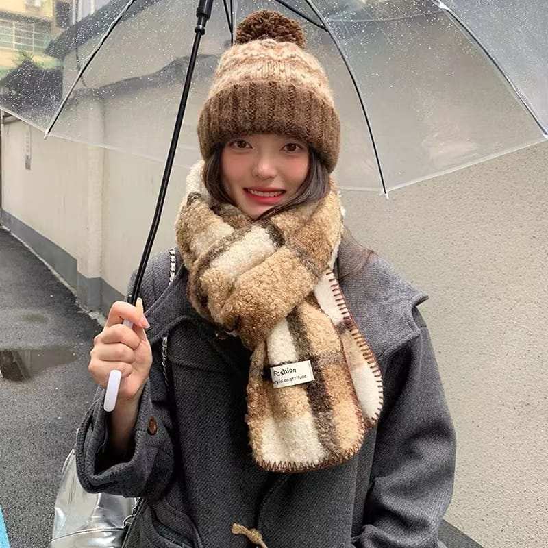 Woman wearing brown cream plaid sherpa scarf and chunky knit pom-pom beanie hat holding clear umbrella in rain - ODM OEM service available - BSCI audit passed supplier
