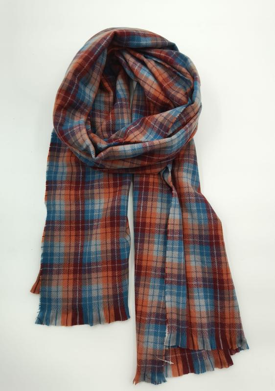 Folded plaid scarf in rust orange, teal blue, and burgundy with fringe edges displayed on white background - contact for custom design quote