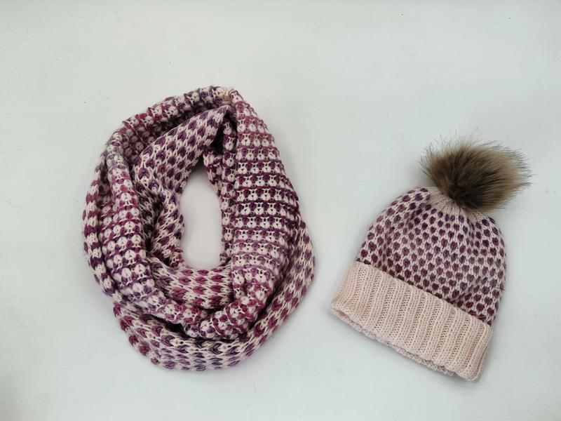 Matching knit winter set with purple and cream infinity scarf and beanie hat with faux fur pom-pom on white background - ask bulk pricing get discount