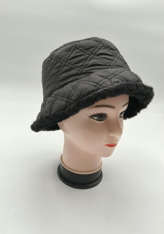 Dark gray quilted bucket hat with black faux fur brim trim displayed on a female mannequin head, product catalog shot - WhatsApp quote in 2 hours