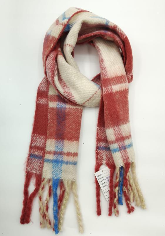 Folded red cream and blue plaid wool-blend winter scarf with multicolor fringe tassels on white background - hotel amenity scarf supplier
