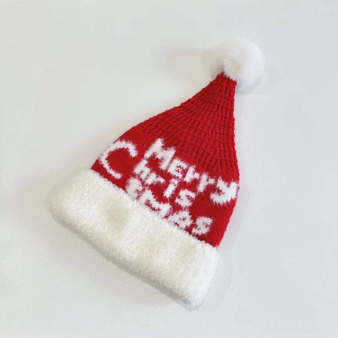 Red knitted Santa Claus hat with white fluffy fur brim, Merry Christmas text pattern, and white pom-pom on top - MOQ 100pcs mixed colors OK