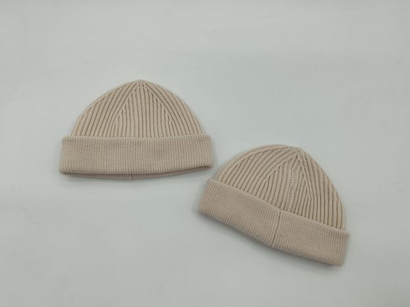 Two beige ribbed knit cuffed beanie hats displayed flat on a white background, showing different sizes - ISO 9001 quality controlled