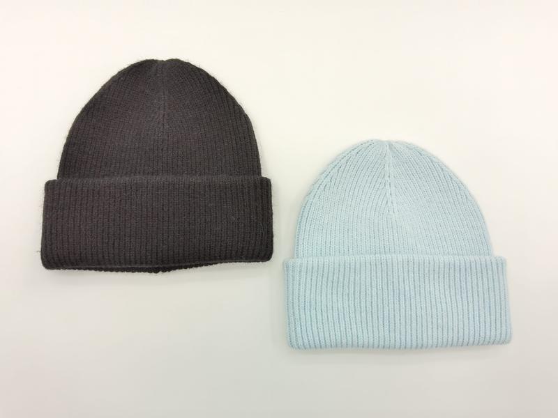 Two ribbed knit cuffed beanie hats laid flat, one charcoal grey and one light blue, on white background - tiered pricing available ask quote