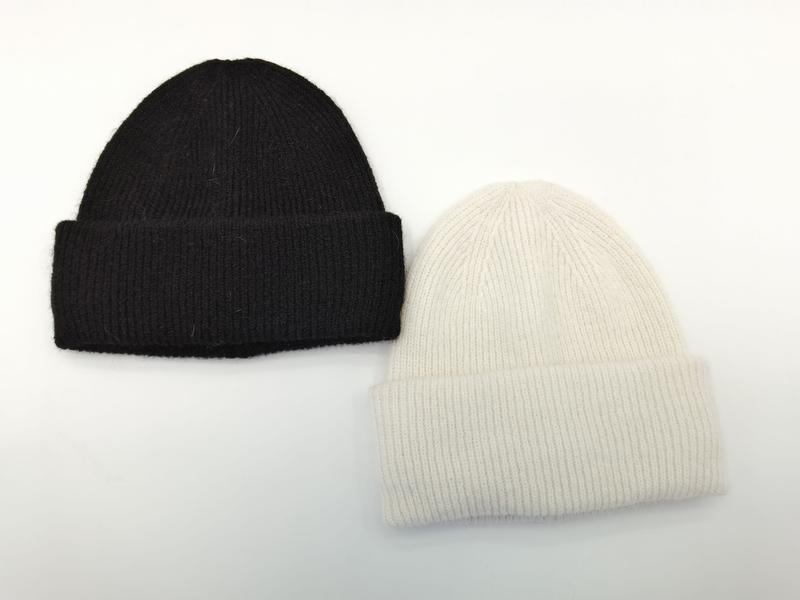 Two ribbed knit cuffed beanie hats laid flat, one black and one cream white, soft wool-blend winter beanies - express production 15 days