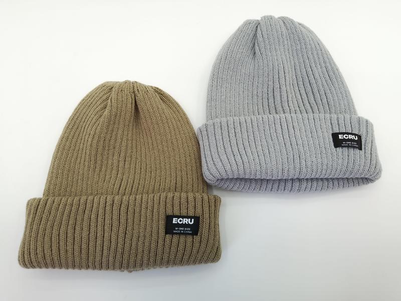 Two ribbed knit cuffed beanies side by side in khaki and light grey with black woven brand label on folded cuff - small batch 100pcs accepted