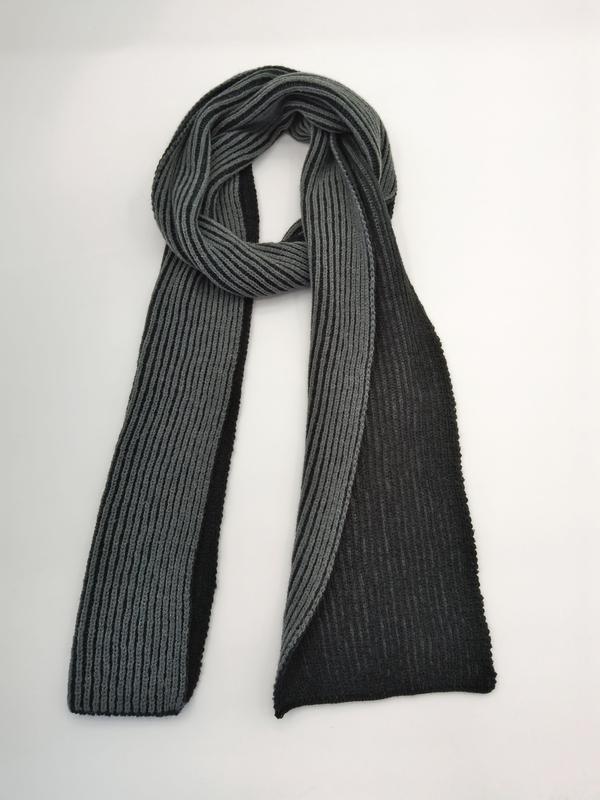 Two-tone ribbed knit scarf in grey and black, looped and draped flat on white background showing texture - private label service available