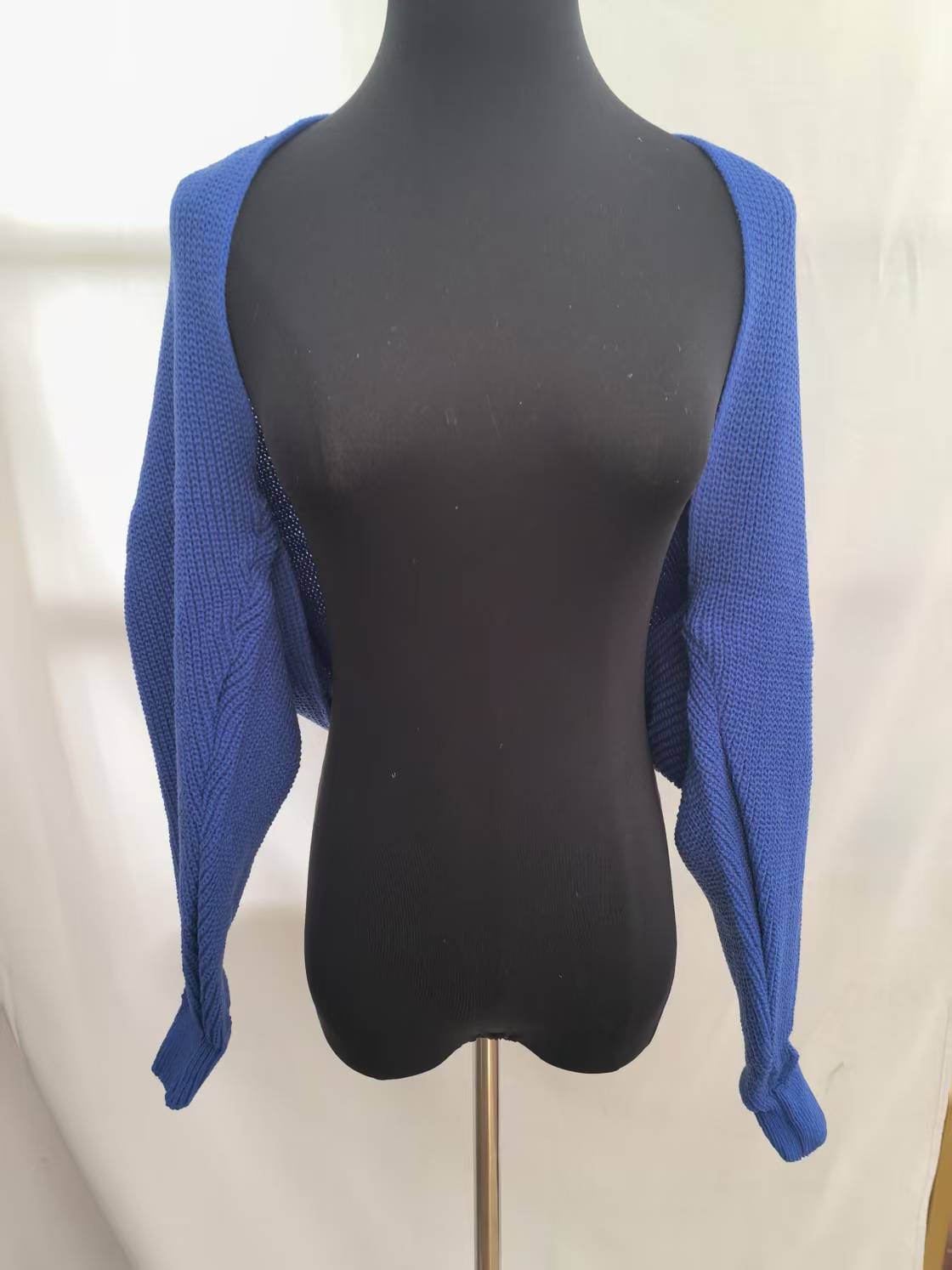 Royal blue chunky knit cropped shrug cardigan with long sleeves displayed on black dress form mannequin - boutique retail bulk order