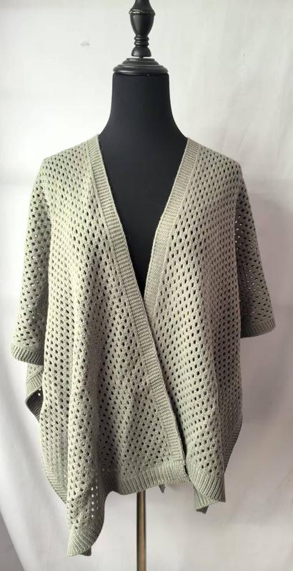 Sage green open-weave knit oversized cardigan wrap displayed on black dress form mannequin, showing loose crochet pattern and short sleeves - BSCI + Oeko-Tex + GRS certified