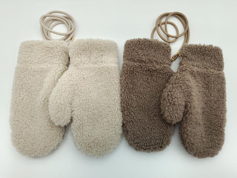 Two pairs of fluffy sherpa fleece mittens in cream and taupe brown, each connected by a leather wrist cord, laid flat on white background - WhatsApp quote in 2 hours