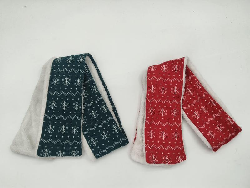 Two folded scarves with white snowflake fair isle pattern, teal and red with sherpa fleece lining, on white background - request quote reply same day
