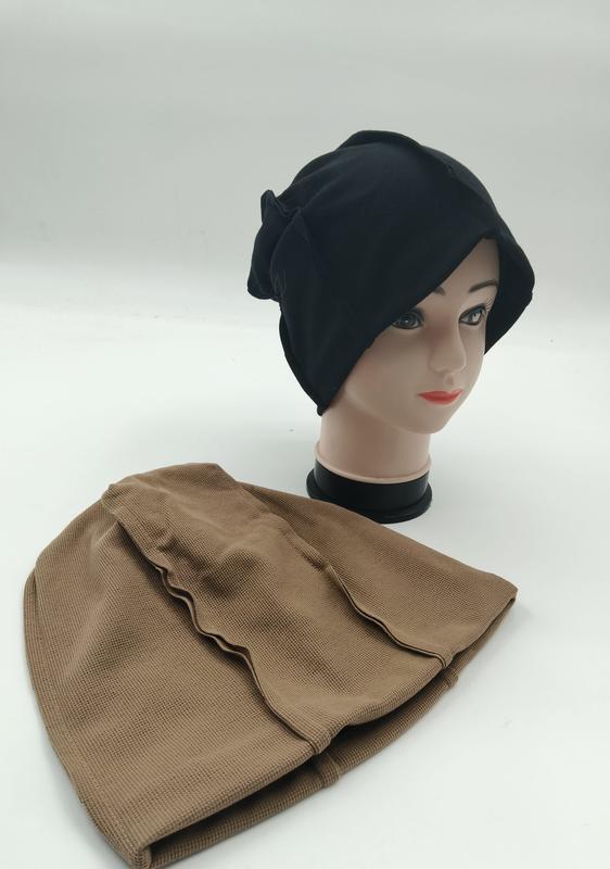 Black slouchy beanie hijab underscarf on mannequin head with tan textured inner cap laid flat beside it - request quote reply same day
