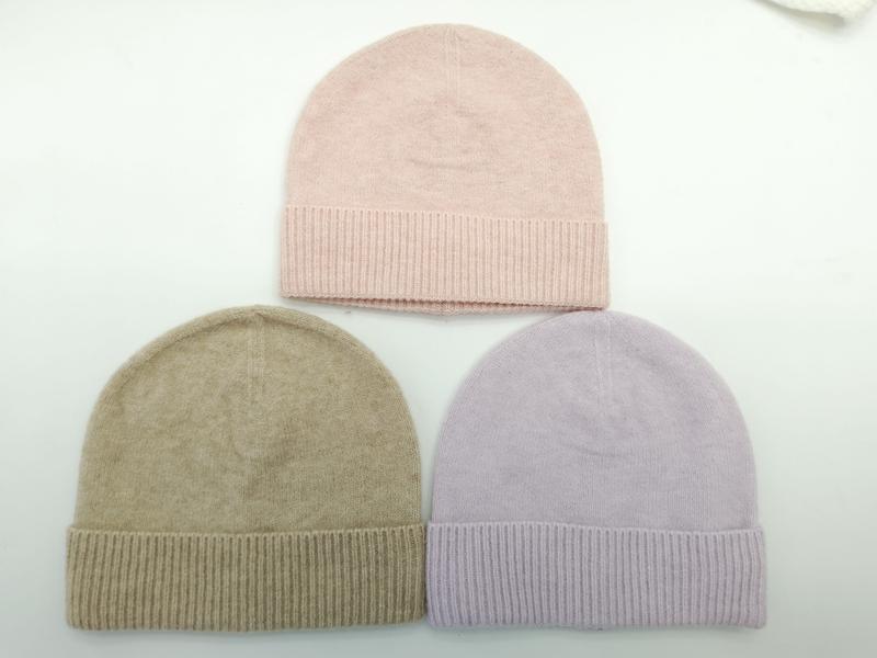 Three knit beanie hats laid flat in blush pink, taupe beige, and lavender with ribbed cuffs on white background - jacquard custom pattern accepted