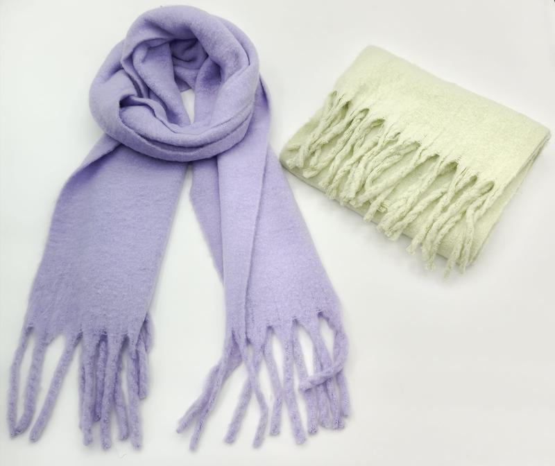 Two soft fuzzy scarves with fringe ends: one lavender looped open and one mint green folded, on white background - wholesale price for USA buyers