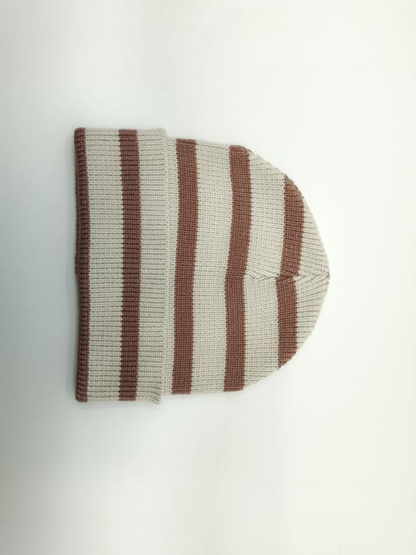 Flat lay of a cream and brown striped ribbed knit beanie hat folded on a white background - wholesale price for Middle East buyers
