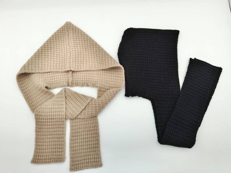 Two waffle knit hooded scarves laid flat, one beige with hood and scarf ends, one black, on white background - custom logo label accepted