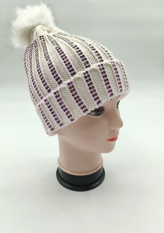 White ribbed knit winter beanie with vertical purple sequin stripes and fluffy faux fur pom-pom on mannequin head - air shipping 5-7 days arrival