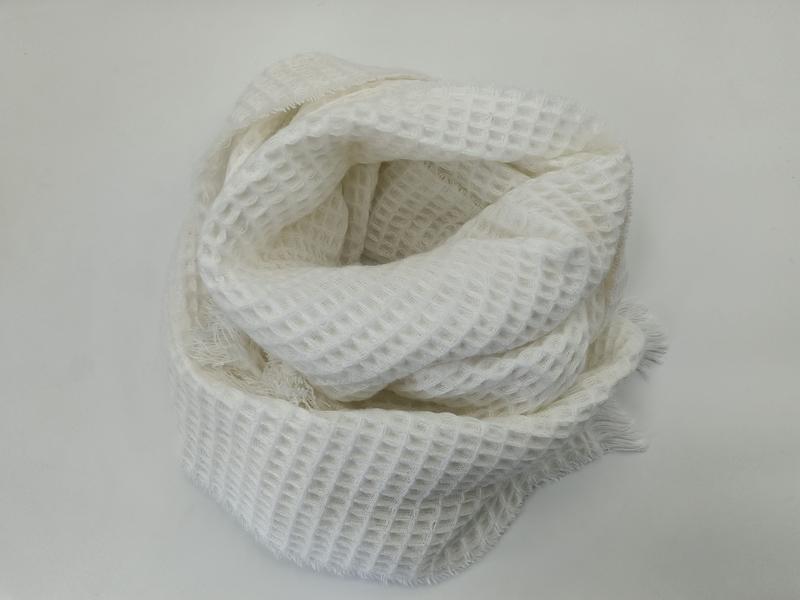White waffle texture knit scarf coiled on white surface showing fringe edges and open weave pattern - WhatsApp quote in 2 hours